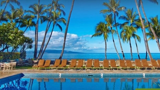 A poolside area with lounge chairs and palm trees, overlooking a body of water. - PICTURESQUE OCEAN VIEW CONDO - LAST MINUTE DEAL!  BEAUTIFUL WAILEA AT ELUA 2002 (Kihei)