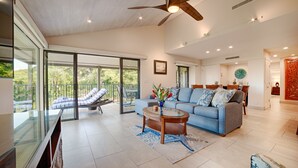 A spacious living room with a large sofa, a coffee table, and a ceiling fan. - PICTURESQUE OCEAN VIEW CONDO - LAST MINUTE DEAL!  BEAUTIFUL WAILEA AT ELUA 2002 (Kihei)