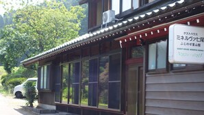 Un bâtiment traditionnel japonais, sur lequel on peut voir une enseigne indiquant qu’il s’agit d’une maison d’hôtes.