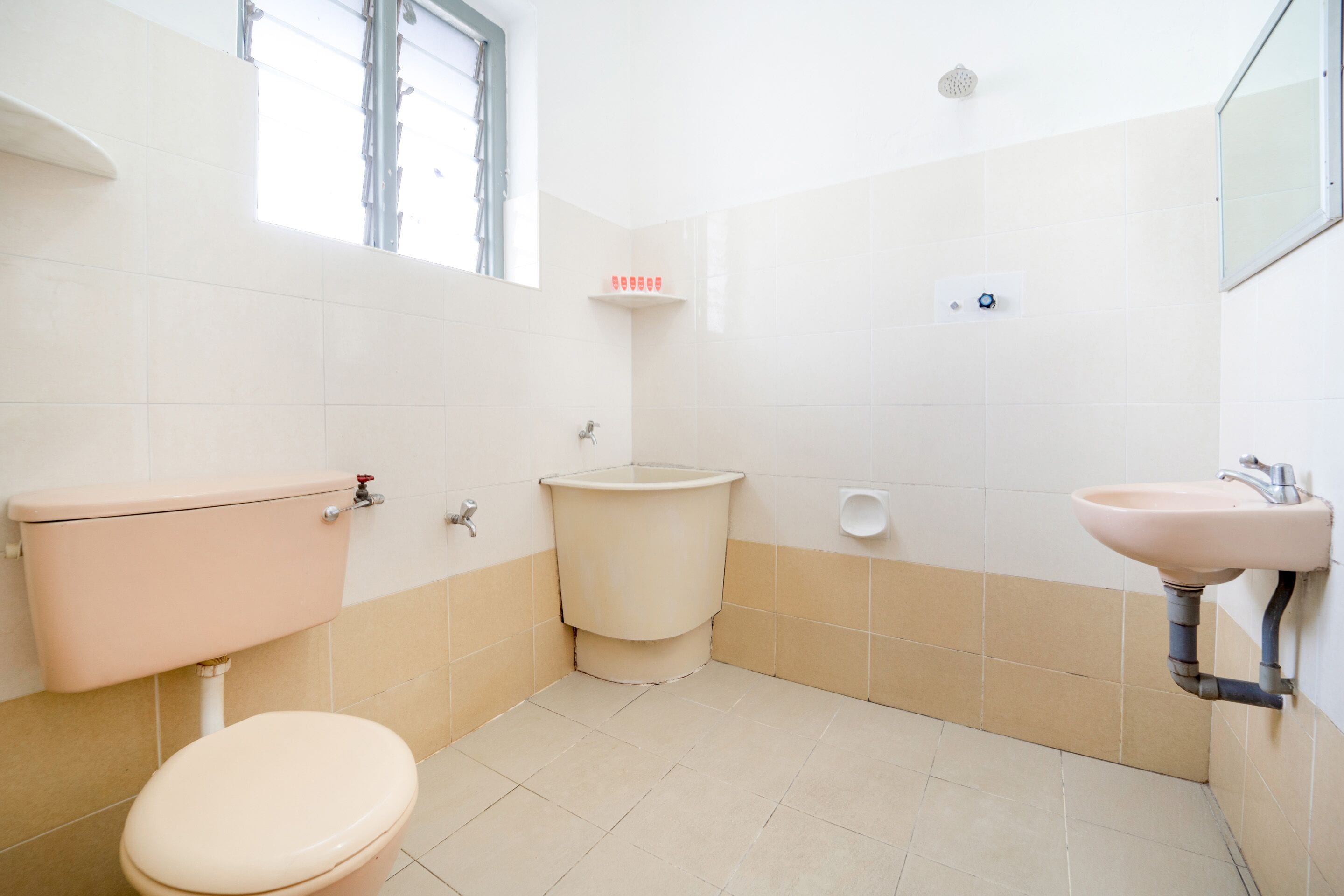 A small, clean bathroom with a toilet, sink, and shower.