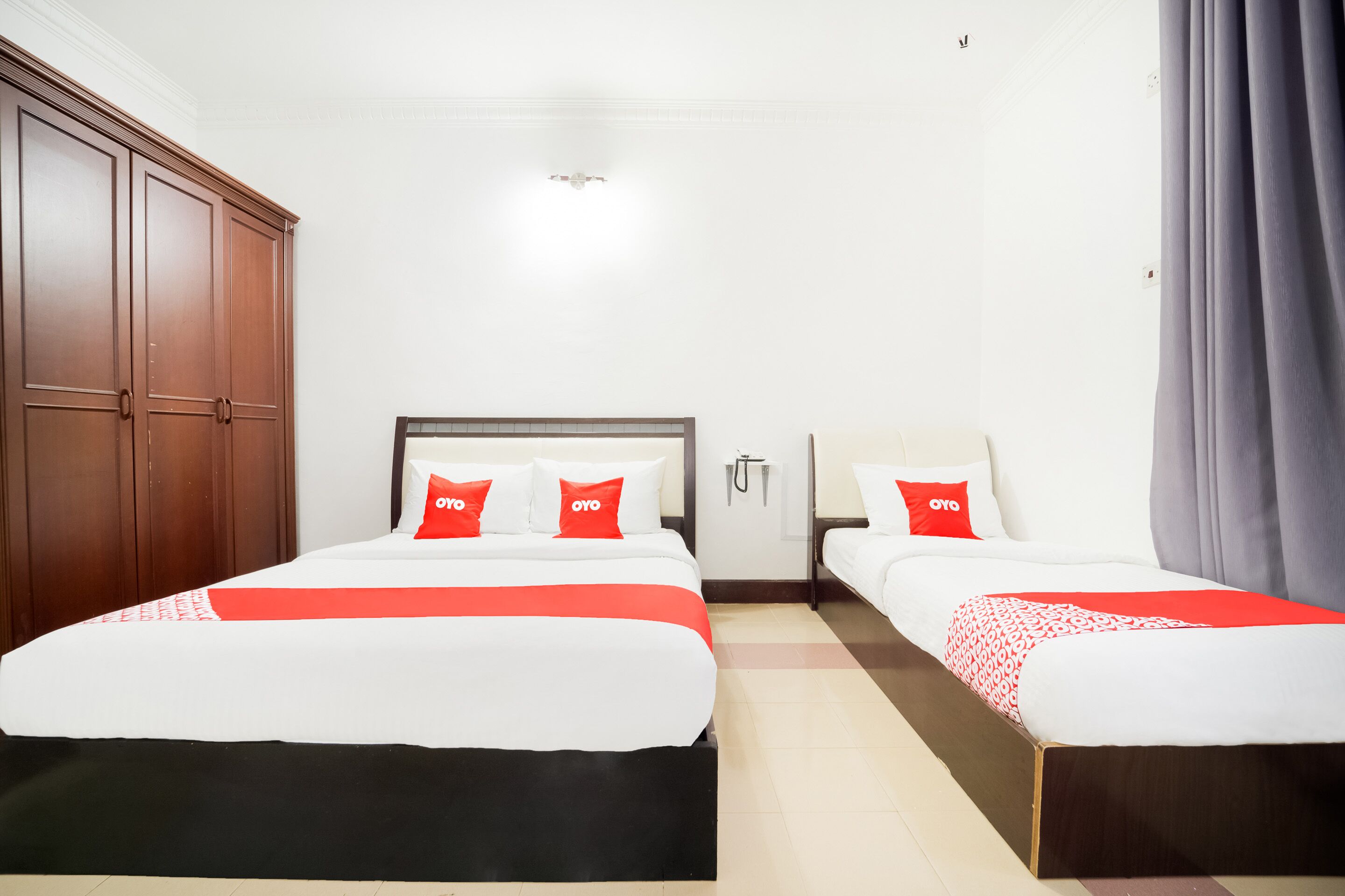 Une chambre d’hôtel avec deux lits, une armoire et une salle de bain.