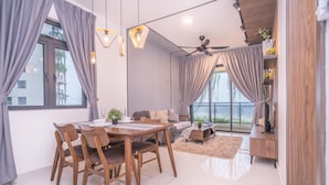 A modern living room with a dining table, chairs, a sofa, and a ceiling fan. - OYO Home 89312 Fantastic 1 Bedroom Starview (Gelang Patah)