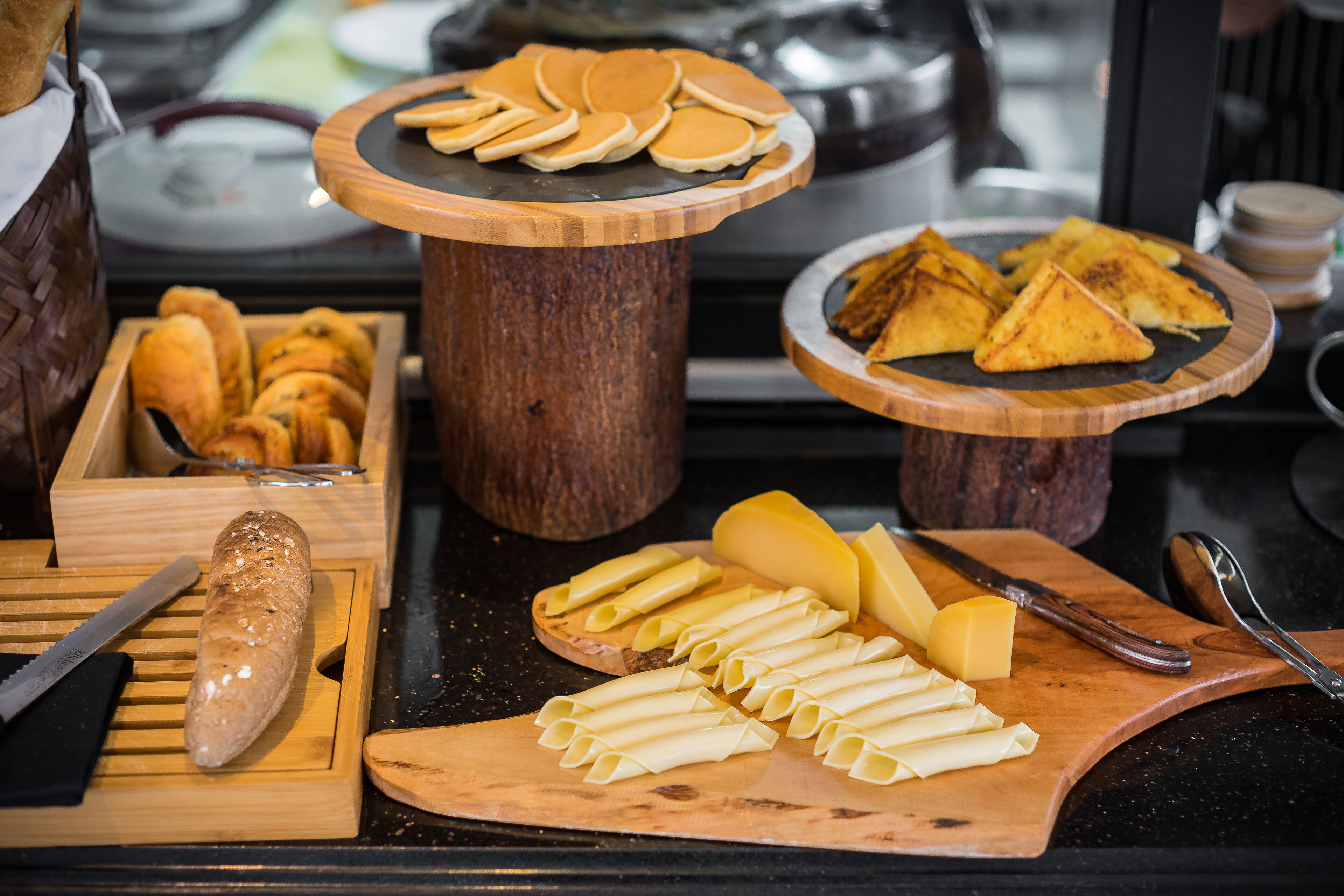 A buffet with various food items including bread, cheese, and pastries.