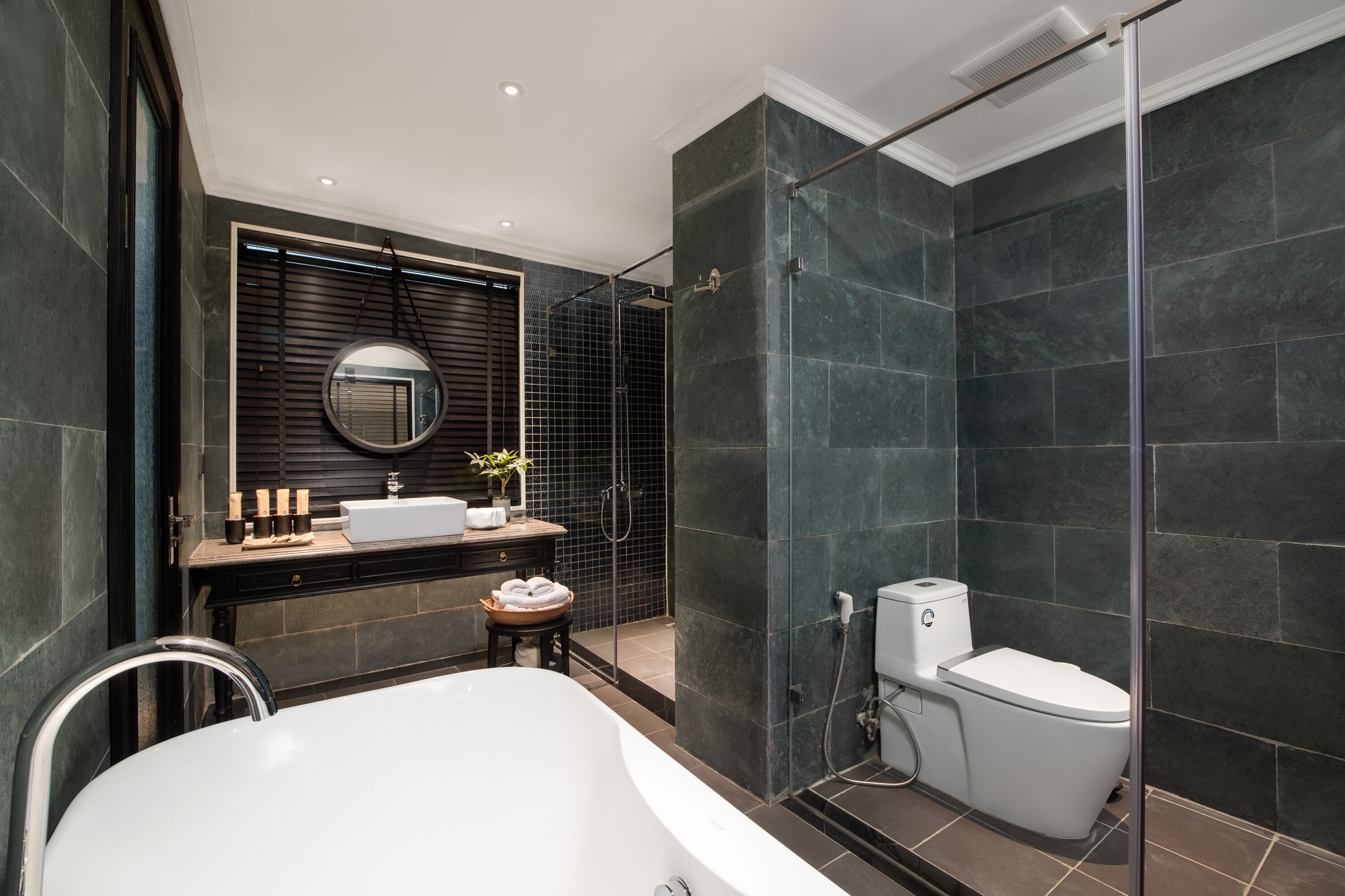 A modern bathroom with a freestanding bathtub, a toilet, and a glass-enclosed shower area.
