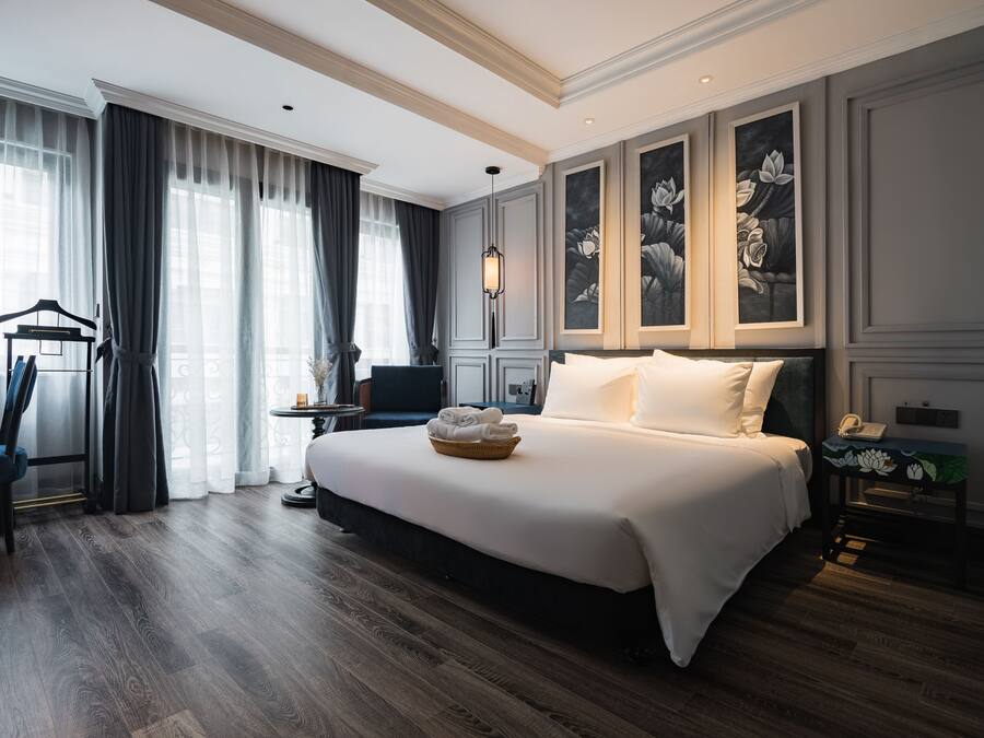Een hotelkamer met een groot bed, een bureau, een stoel en een kledingkast.