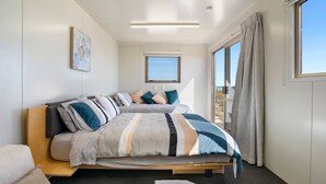 Une chambre à coucher avec un lit, une fenêtre et une vue sur l’extérieur.