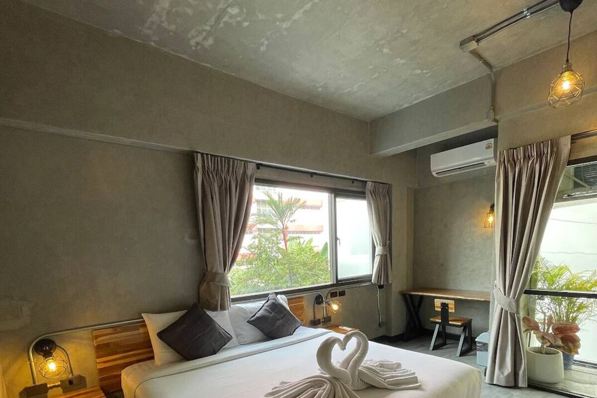 Een moderne hotelkamer met een groot bed, een bureau en uitzicht op de omgeving.