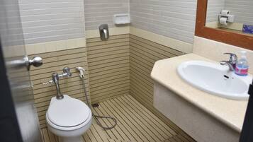 A bathroom with a toilet, sink, and mirror.