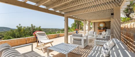 A covered outdoor seating area with a view of the landscape.