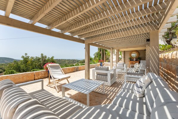 A covered outdoor seating area with a view of the landscape.