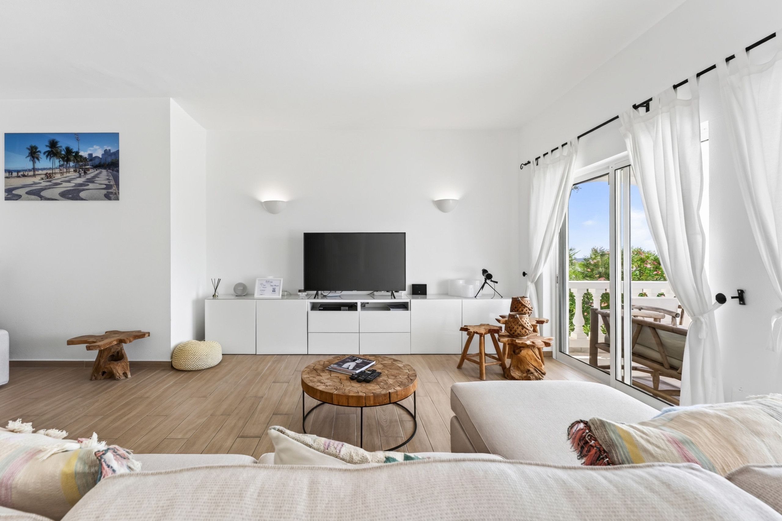Un salon moderne avec un téléviseur à écran plat, une table basse en bois et un canapé.