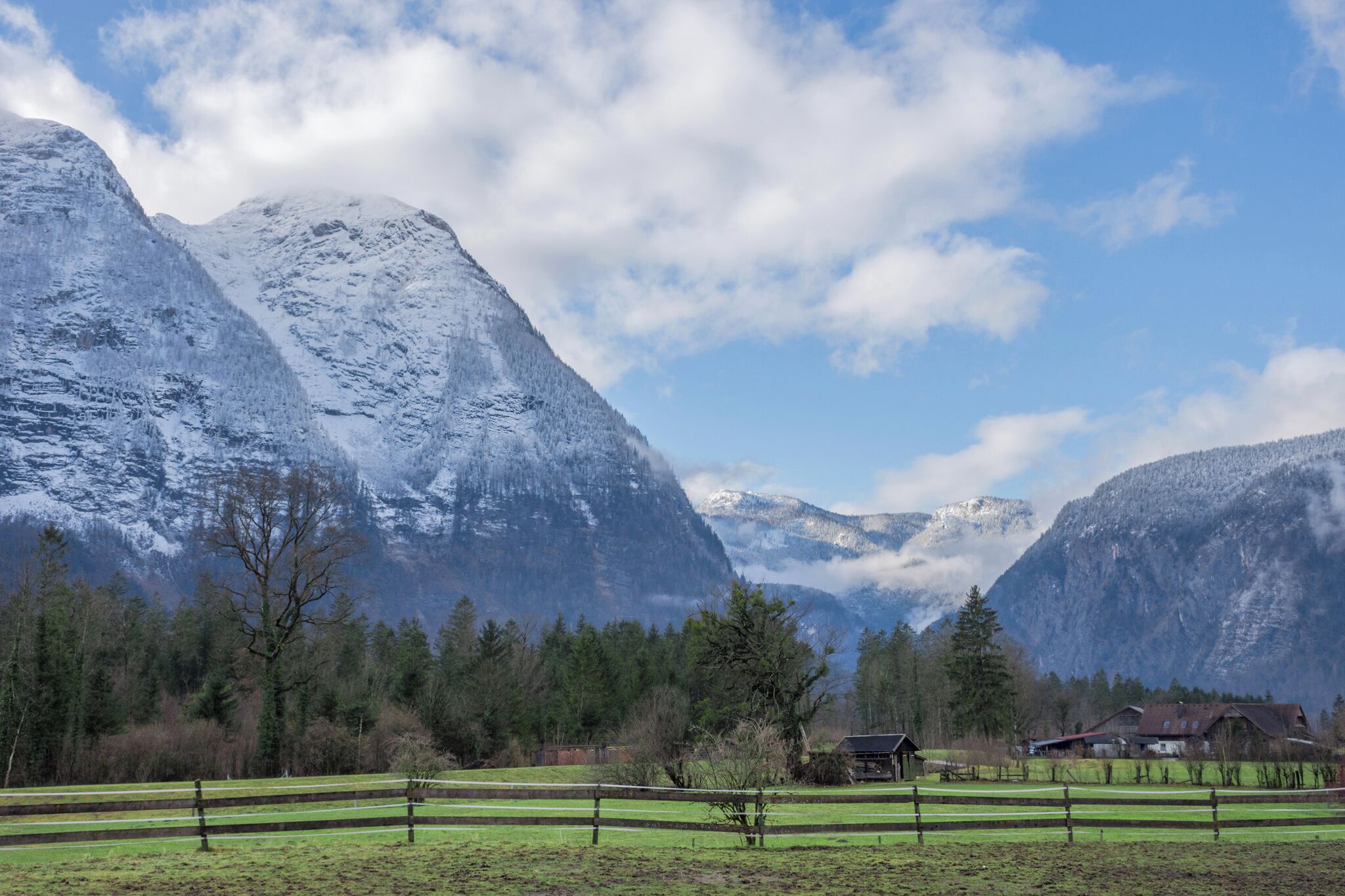 A mountainous landscape with snow-covered peaks and a clear sky.