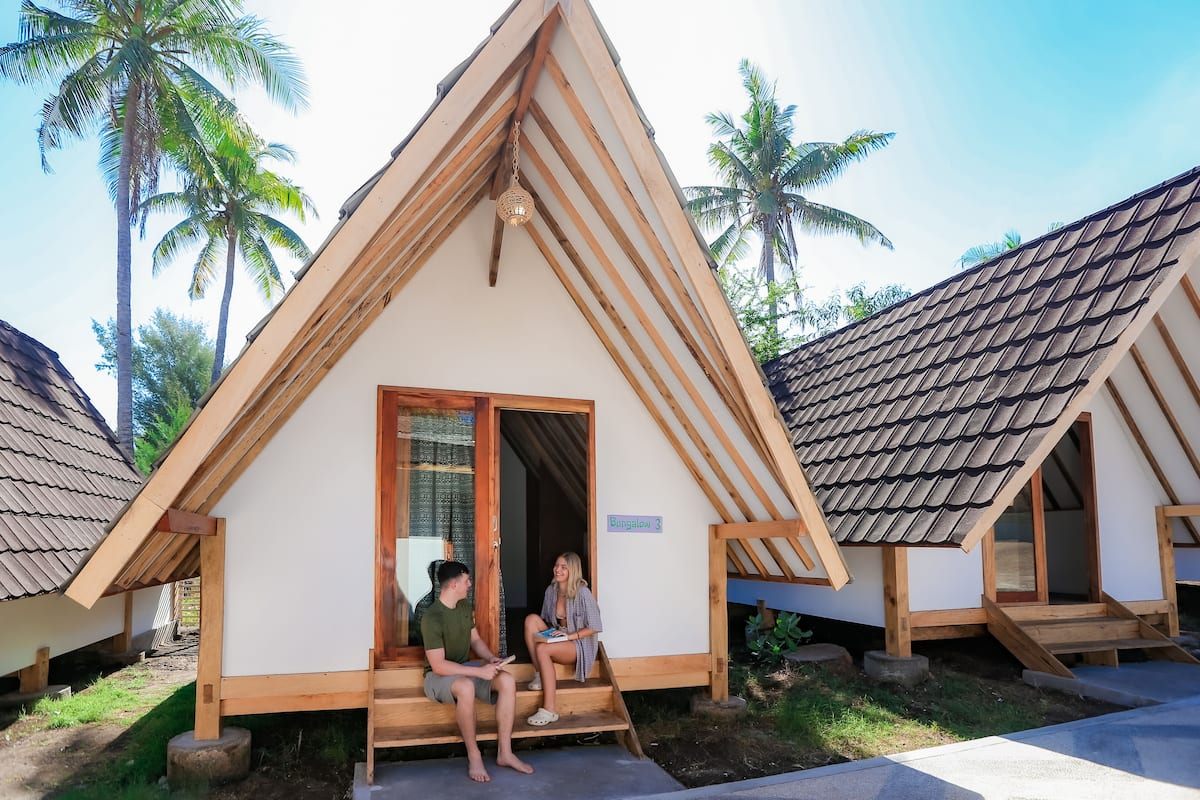 Ein Bungalow mit schrägem Dach, Holzbalken und einer kleinen Veranda.