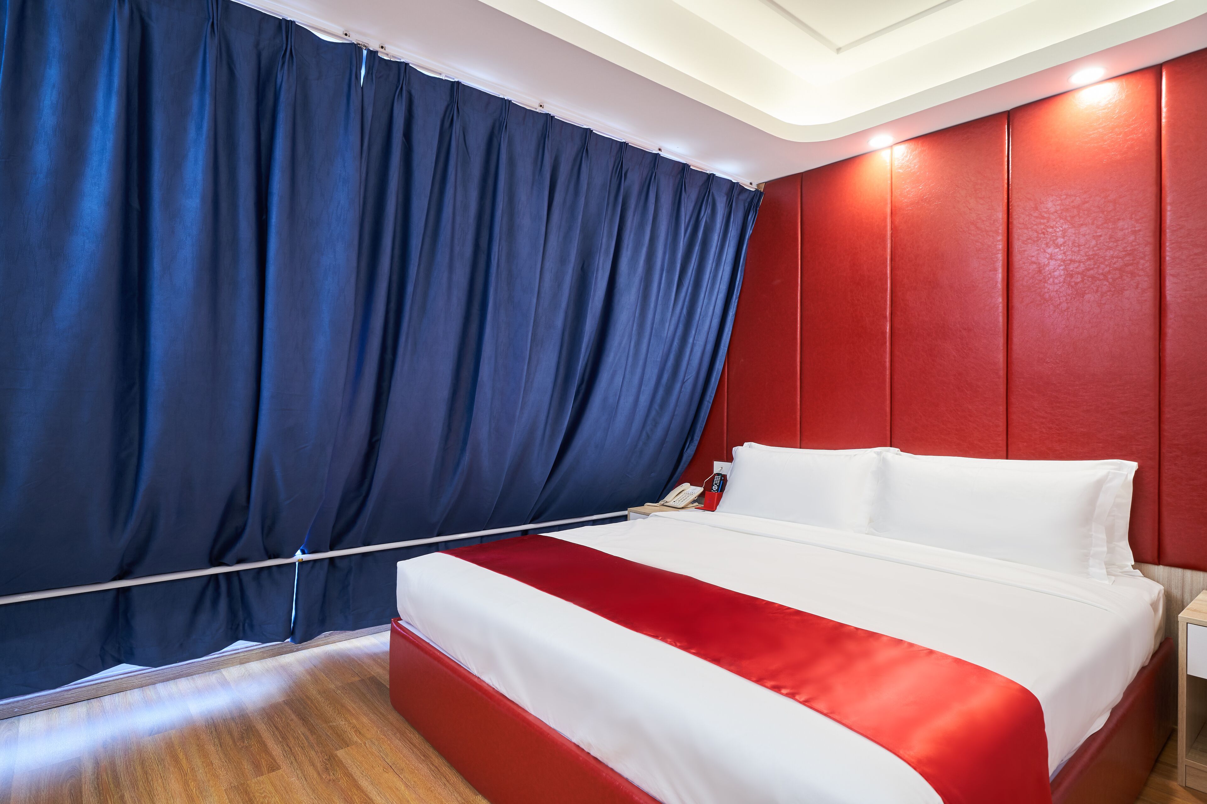 Une chambre d’hôtel avec un lit, des rideaux et une table de chevet.