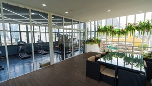 A spacious indoor area with a large glass wall, a wooden floor, and a seating area with cushions. - Sapphire Hotel Silom Bangkok (Bangkok)