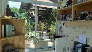 A room with a desk, computer, and shelves with books and decorative items. - BeauBo Beach (Ko Pha-ngan)