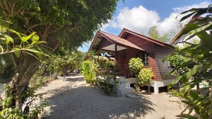 A wooden house with a covered porch, surrounded by greenery and a clear sky. - BeauBo Beach (Ko Pha-ngan)