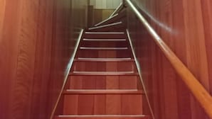 Una escalera de madera con barandilla que lleva a una plataforma.