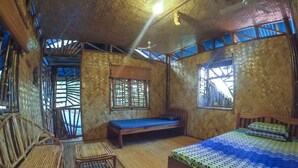 A room with a bed, a bench, and a chair. - Bamboo Nest Palawan - Hostel (Puerto Princesa)