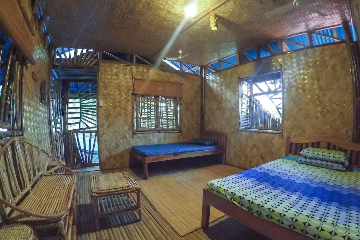 Ein Zimmer mit einem Bett, einer Bank und einem Stuhl.