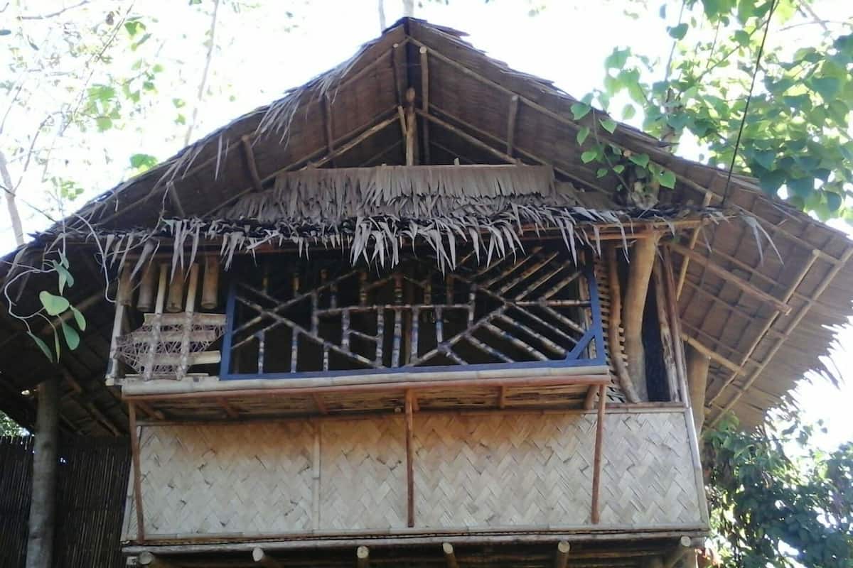 Ein traditionelles Haus mit einem Strohdach, einem gewebten Fenster und einer Bambuskonstruktion.