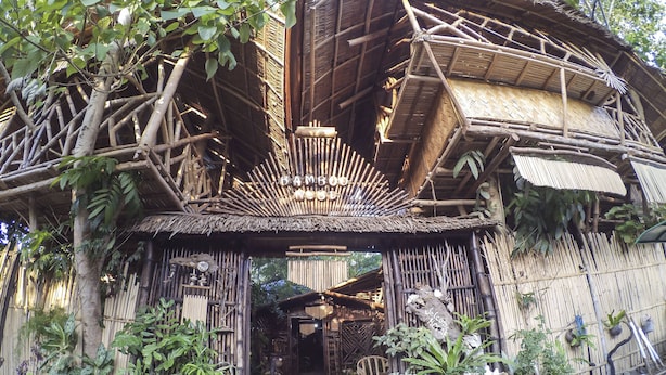 A bamboo structure with a thatched roof, surrounded by potted plants. - Bamboo Nest Palawan - Hostel (Puerto Princesa)