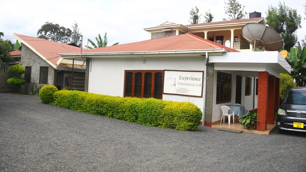 Un edificio de dos pisos con un letrero que dice 'Experience Tanzania Co. Ltd.' en la fachada.
