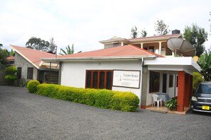 A two-story building with a sign for 'Experience Tanzania Co. Ltd.' on the front. - Mama Simba Arusha Homebase (Arusha)