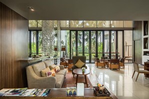 Relax in a spacious lobby with a seating area, reception desk, and large windows offering views of the surrounding greenery.