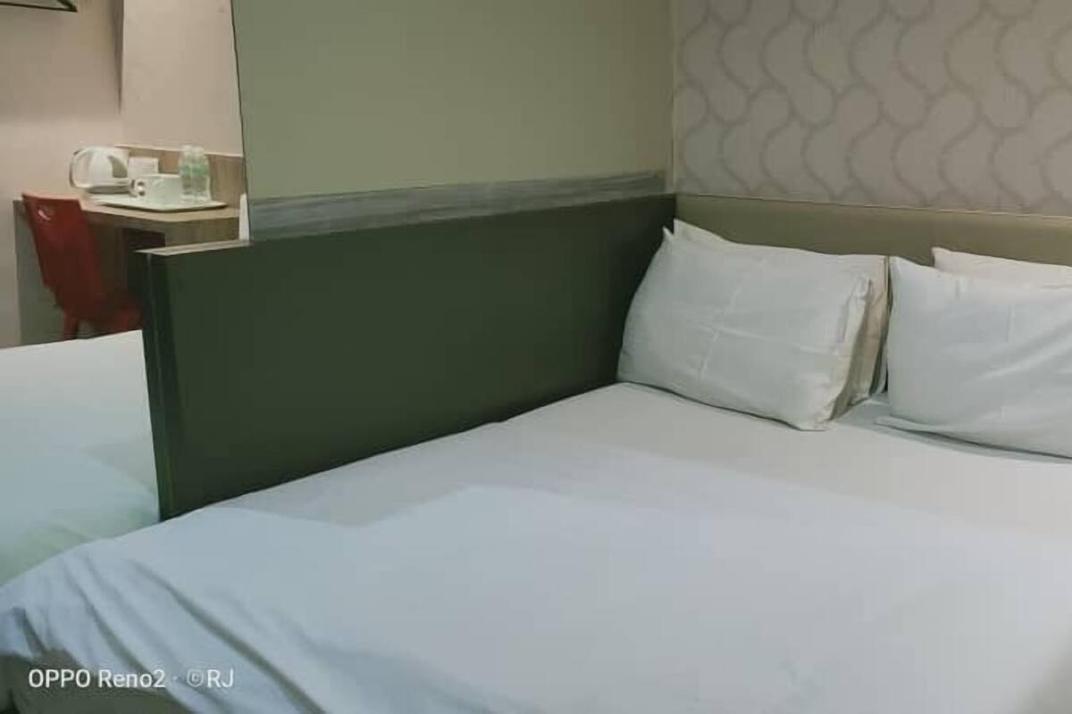 A hotel room with a bed, a desk, and a chair.