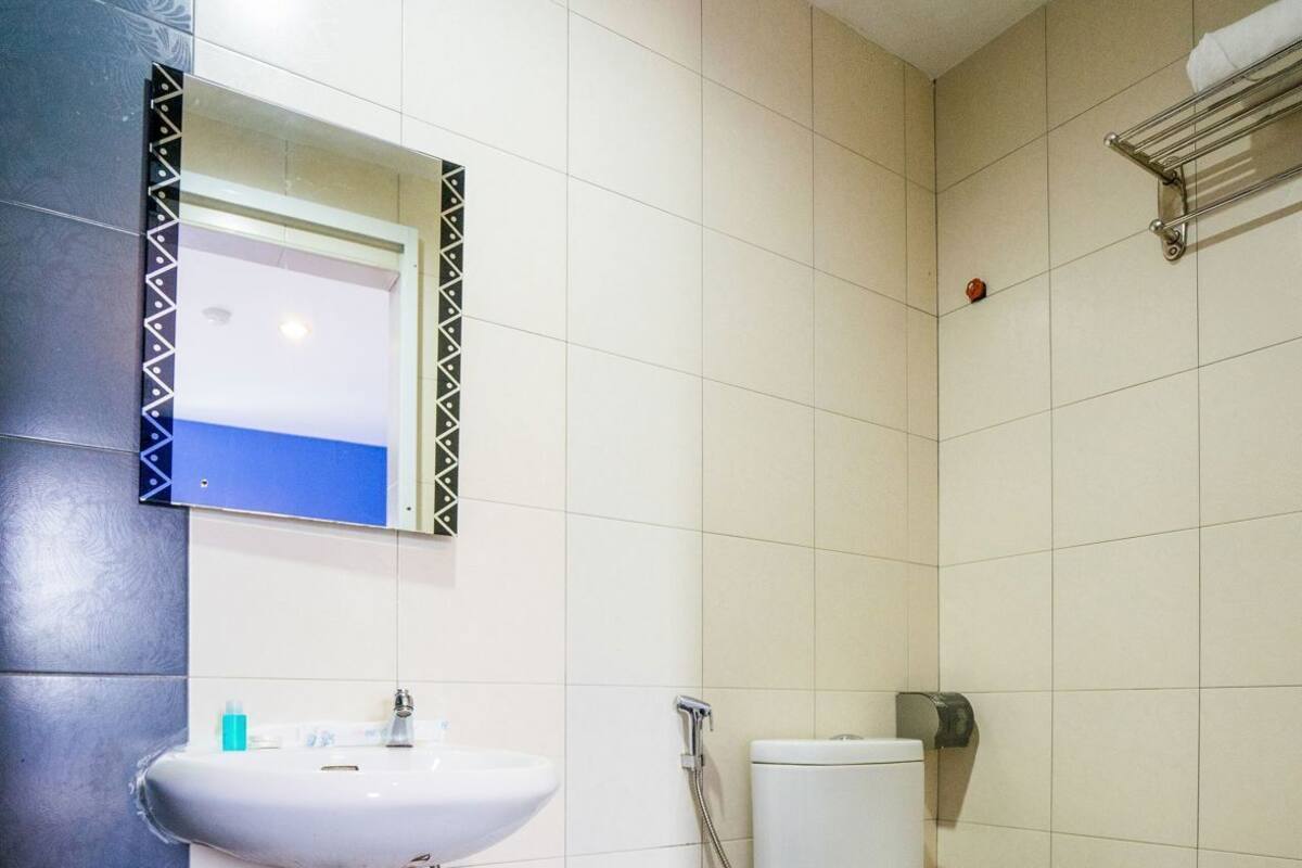 A bathroom with a white sink, a toilet, and a shower.