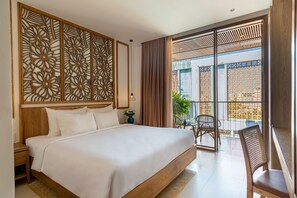 Ein Hotelzimmer mit einem großen Bett, einem Holzkopfende, einer dekorativen Wandverkleidung, einem Balkon mit Aussicht und einer Sitzecke mit Stühlen.