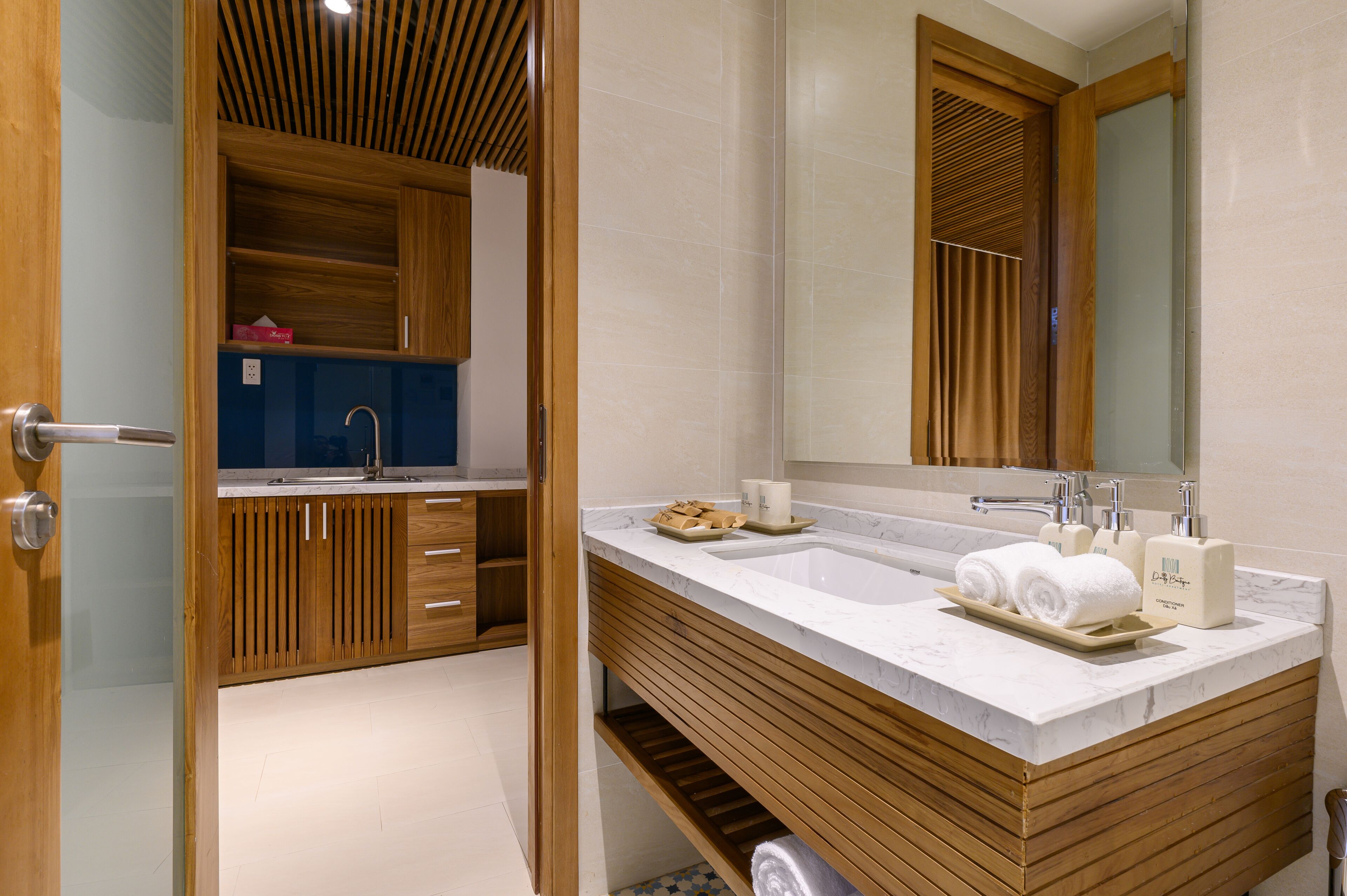 A modern bathroom with a wooden vanity, a large mirror, and a sink.
