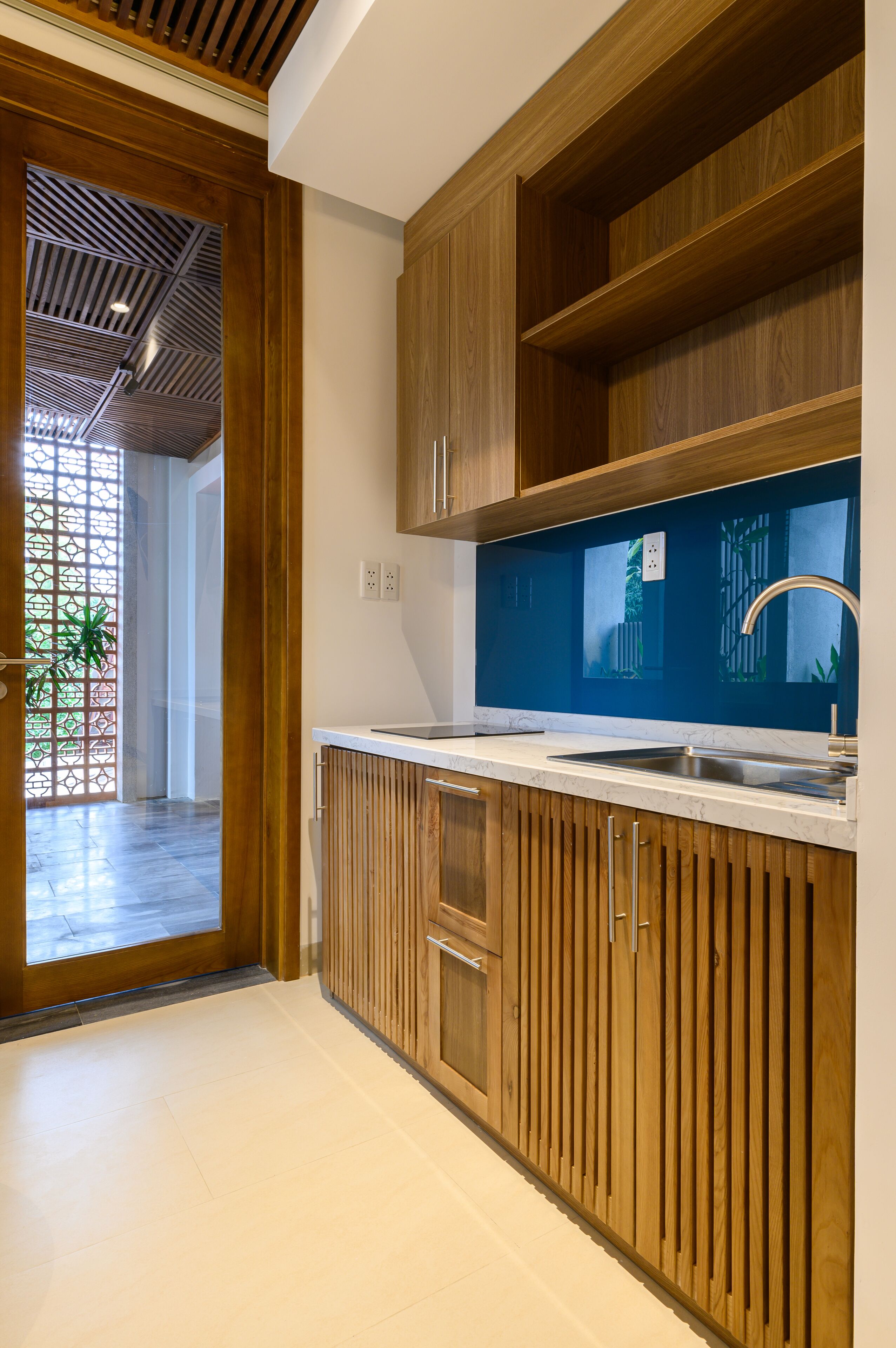 A modern kitchen with wooden cabinets, a white countertop, and a built-in sink.