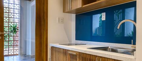 A modern kitchen with wooden cabinets, a white countertop, and a built-in sink.