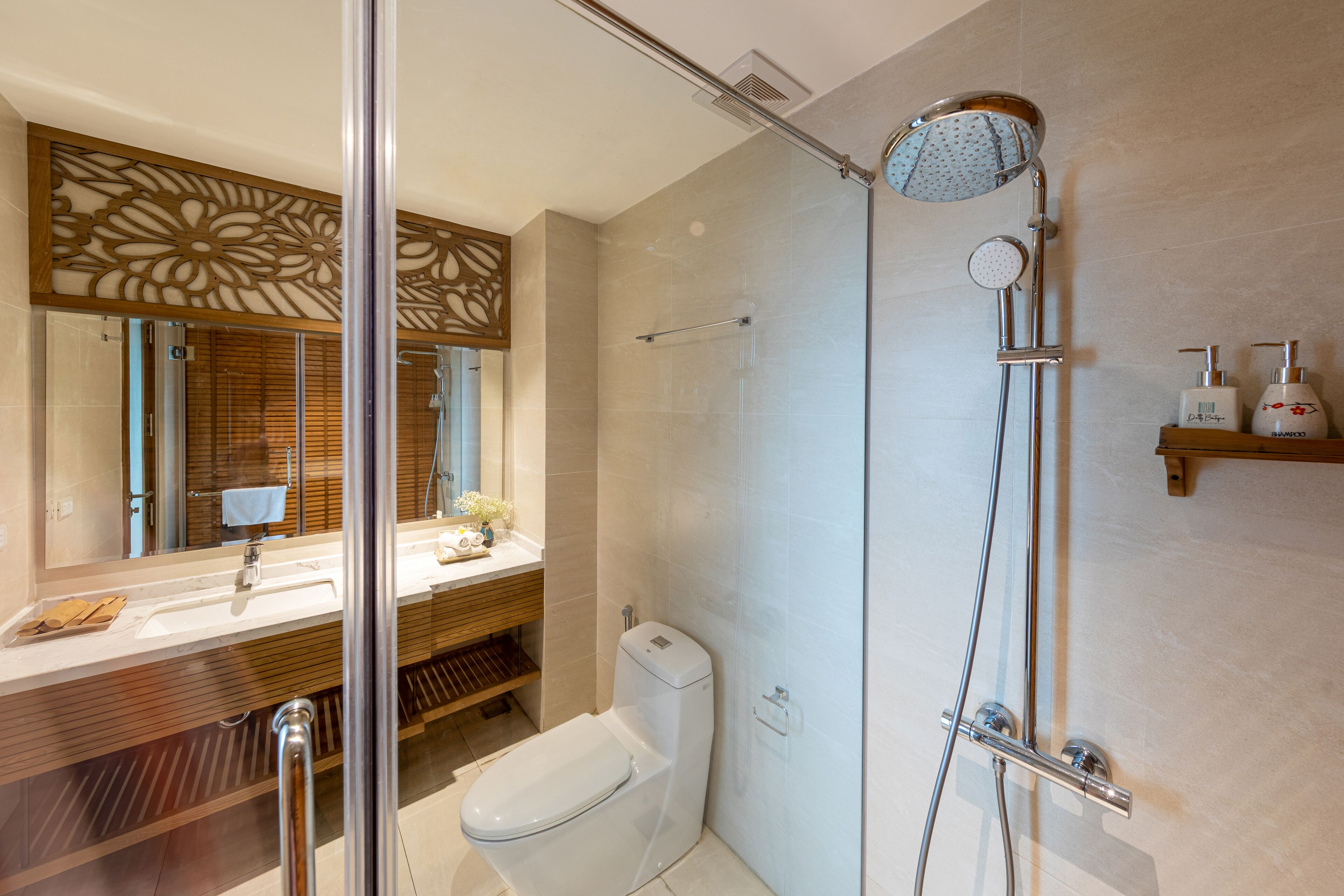 A modern bathroom with a glass shower enclosure, a toilet, and a vanity with a mirror.