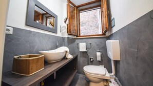 A bathroom with a bathtub, a toilet, a sink, a mirror, and a window.