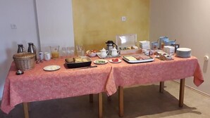A breakfast buffet setup with multiple tables covered in pink tablecloths, featuring a variety of food items and beverages. - Gasthof's Gräbele (Tuebingen)