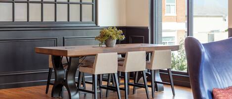Un comedor con una mesa de madera, cuatro sillas y una planta en maceta.
