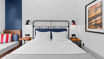 Una habitación de hotel moderna con cama, mesitas de noche y una obra de arte colgada en la pared.