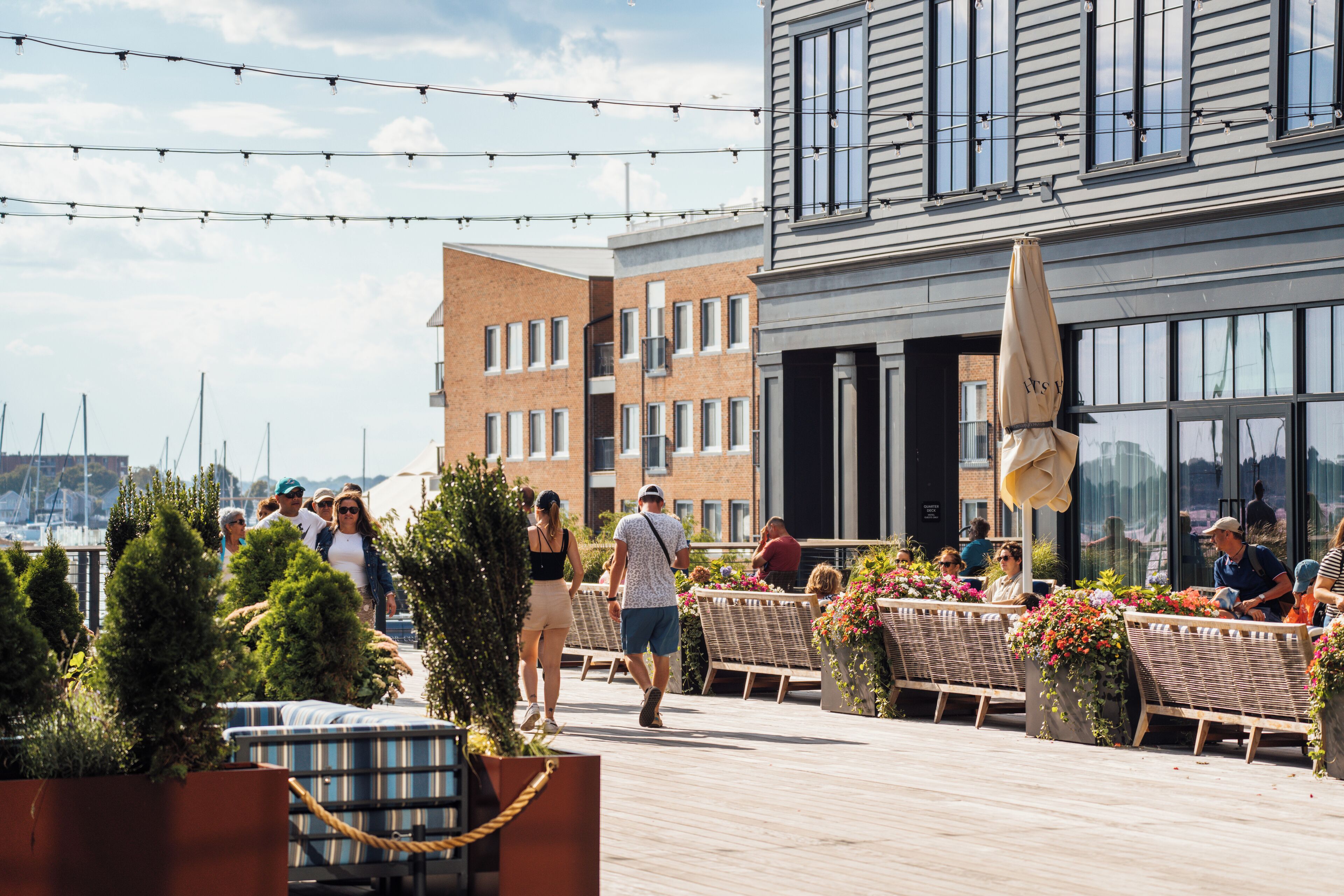 A rooftop terrace with outdoor seating, potted plants, and a view of the city skyline.