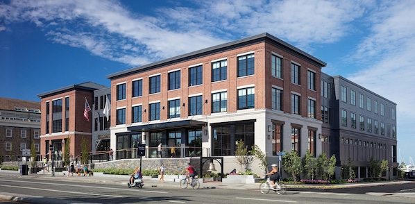 A modern hotel with a brick facade, large windows, and a covered entrance area.