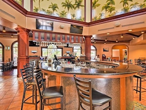 Relax with a drink at the hotel's bar, featuring a curved countertop and comfortable seating.
