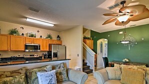 Un salon avec deux canapés, une table basse et un ventilateur de plafond.