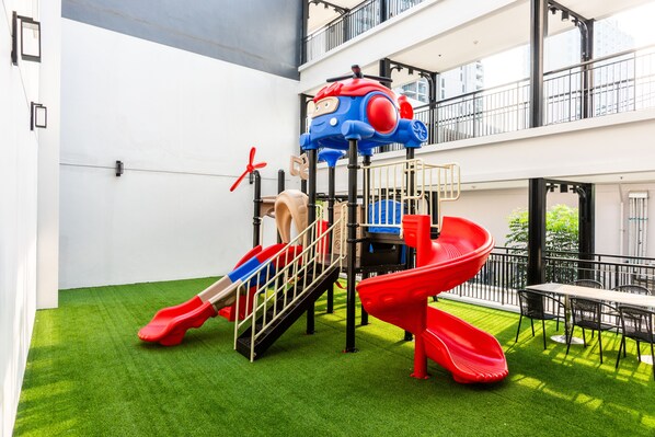 Ein Kinderspielbereich mit Rutschen und einer Kletterkonstruktion.