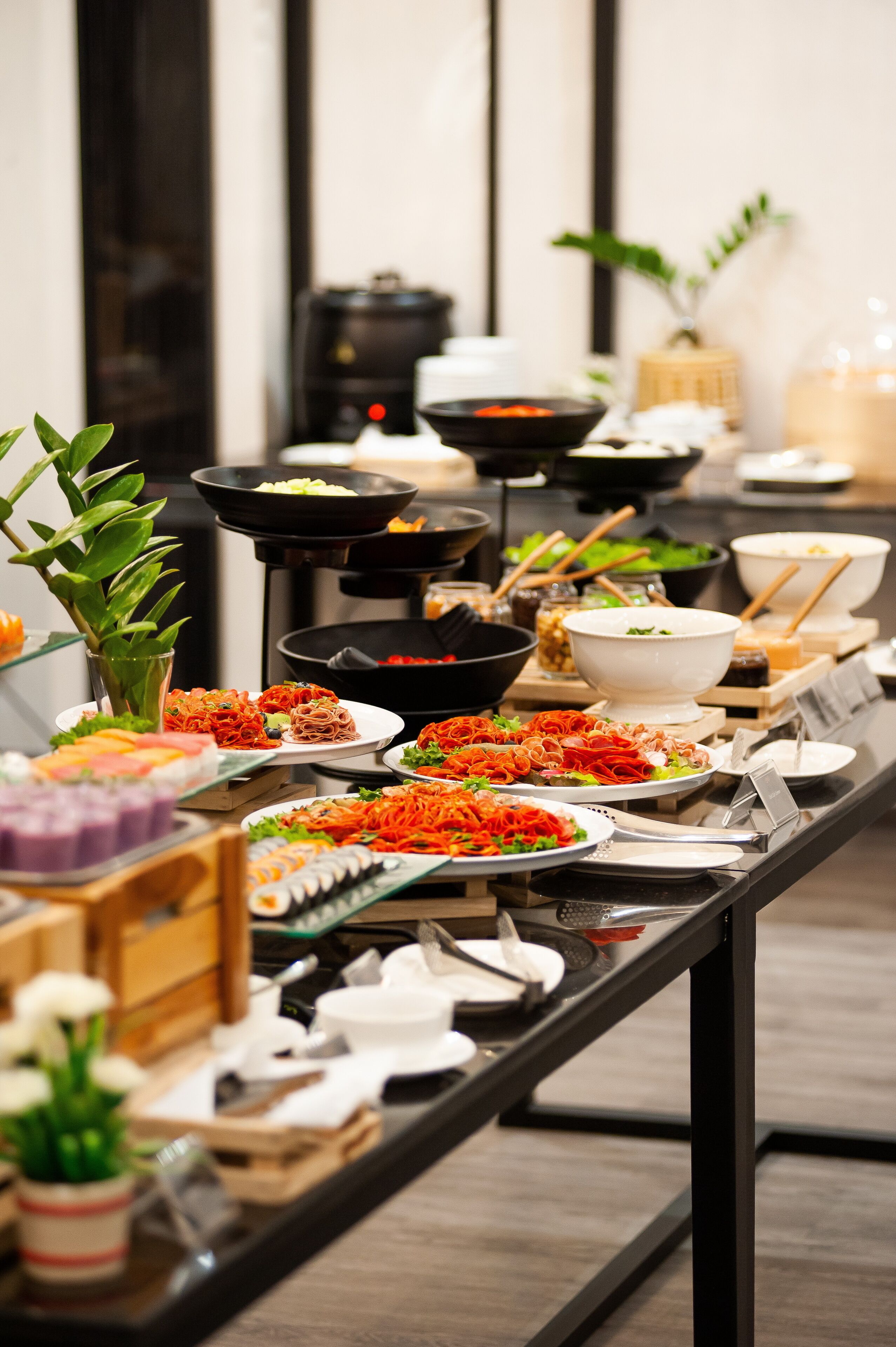 A buffet table with various dishes and utensils.
