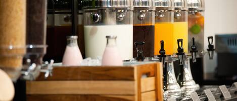 A beverage station with multiple dispensers, each with a different colored liquid, and a wooden crate in the foreground.