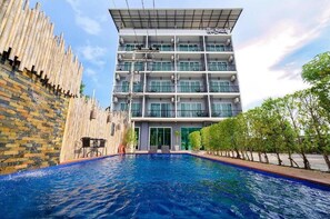A hotel with a swimming pool, multiple balconies, and a modern architectural design. - The Beach at Klong Muang (Krabi)