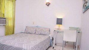 Ein Schlafzimmer mit einem Bett, einem Schreibtisch und einem Stuhl.