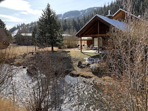 Escape to a serene mountain retreat with a stream and lush surroundings.